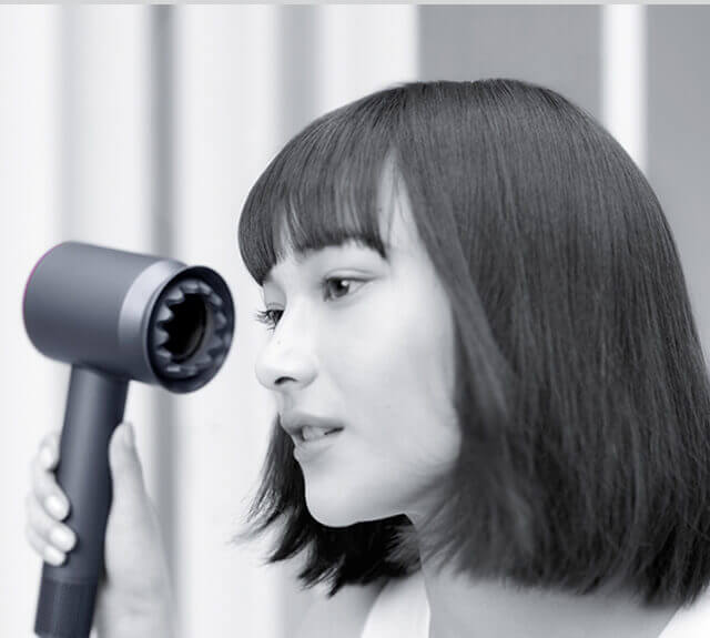 Woman drying her hair with the Dyson supersonic hair dryer