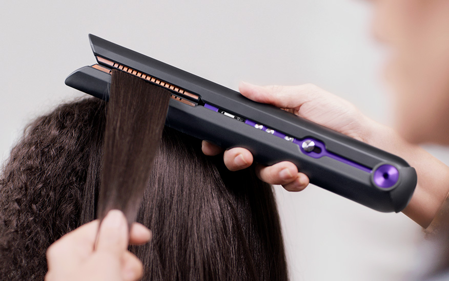 Professional stylist using the Dyson Corrale hair straightener