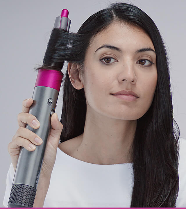 A woman holding the Dyson digital motor V9